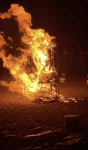 Image of a burning female statue made of wood taken from exonerate.agnes instagram